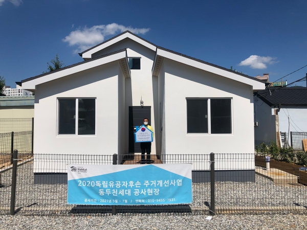 ▲독립유공자 故 최덕주 선생의 손자 최재국 씨가 LX한국국토정보공사ㆍLX하우시스ㆍ한국해비타트가 함께 새로 만든 자택 앞에서 기념촬영을 하고 있다./제공=LX공사