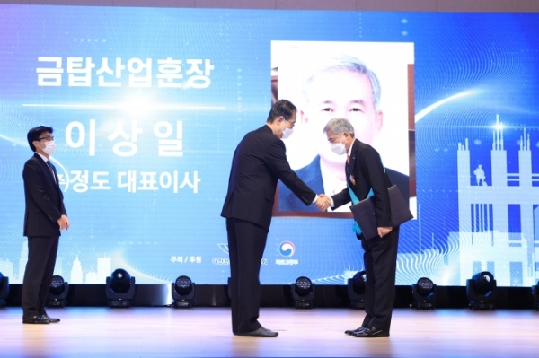 이상일 정도 대표이사가 한덕수 국무총리로부터 금탑산업훈장을 수여받고 있다./출처=국토교통부