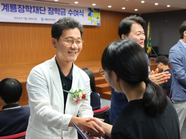 이승찬 계룡장학재단 이사장이 웃으면서 고등학생‧대학생에게 장학증서와 장학금을 전달하고 있다./사진= 계룡건설