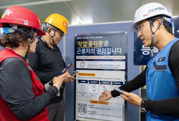 DL이앤씨 현장 안전관리자(우측 첫번째)가 현장 근로자들에게 안전신문고 접속 및 작업중지권 사용법에 대해 설명하고 있다./사진=DL이앤씨