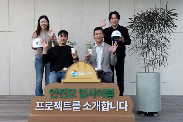 사진 우측 2번째 GS건설 허윤홍 대표 및 직원들이 바이바이 플라스틱 챌린지에 참여하며, 현장에서 발생한 폐안전모를 재활용해 만든 제품(책상, 의자, 화분)과 함께 기념사진 촬영을 하고 있다./사진=GS건설 제공