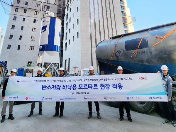 롯데건설이 지난 6일 한일시멘트와 함께 개발한 ‘CO주입 바닥용 모르타르’ 기술을 현장에 적용하고 기념사진을 촬영하고 있다./사진=롯데건설