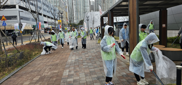 행복청과 코오롱글로벌은 체육관 주변 환경을 깨끗하게 가꾸기 위해 화단과 공용구간 쓰레기를 수거하고 외부공간을 정비하고 있다./사진=행복청